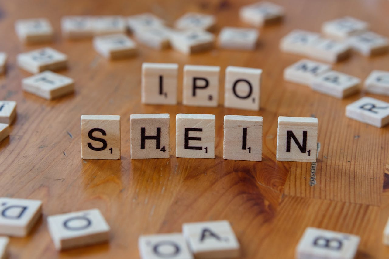 Creative representation of Shein's IPO using letter tiles on a wooden surface.